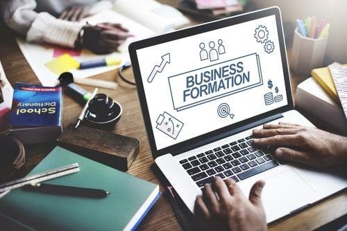 Business formation concept with laptop and office supplies on desk.